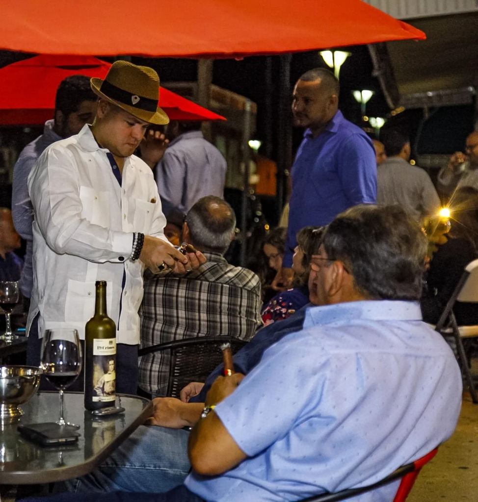 Randy Pérez sirviendo puros a clientes en una Cigar Night